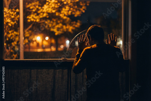 Man looks out window at night