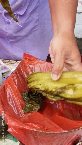 Preparing Pickled Mustard Greens for Weighing. Selling at a traditional market