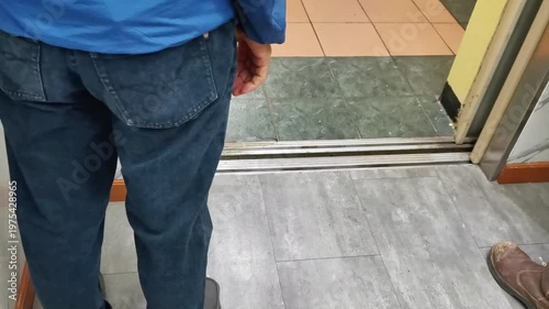 Person walking in of elevator doorway with casual shoes and indoor flooring perspective
