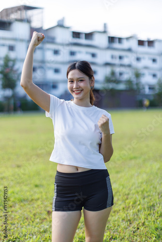 Young woman celebrating success with arms raised outdoors