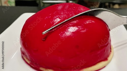 Glossy red layered dessert with sponge cake mousse and fruit filling