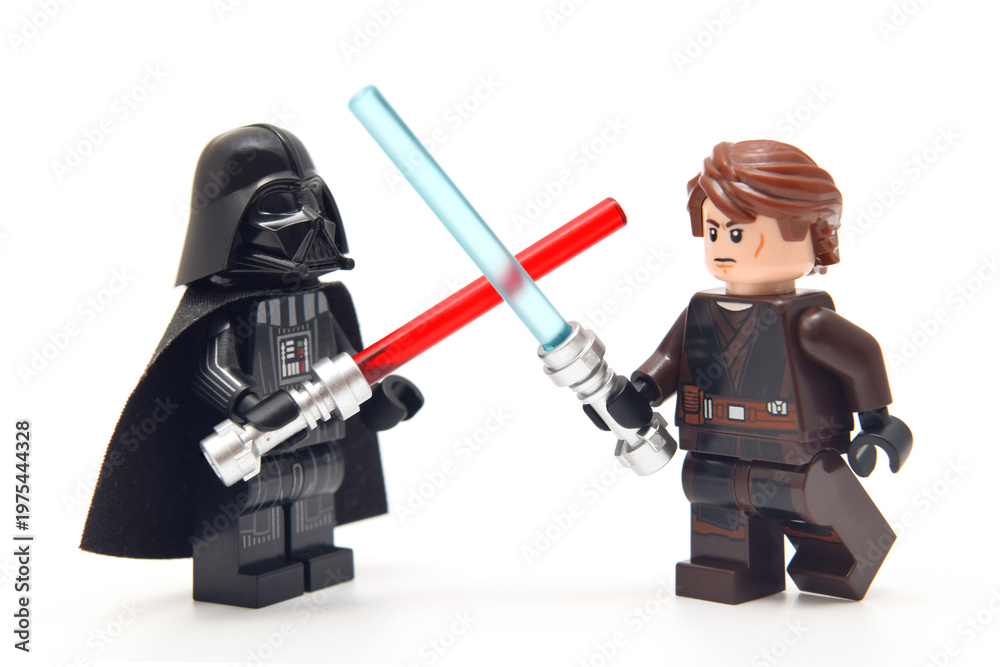 Obraz premium Lego minifigure of Darth Vader from Star Wars with red lightning sword against an Anakin with blue sword isolated on white. Editorial illustrative image of popular plastic constructor.