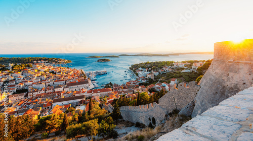 Fotografia Stunning sunset over Hvar town and Pakleni Islands viewed from the medieval Spanish Fortress, golden hour over the Adriatic sea, Croatia