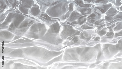 Clear water surface with light reflections creating abstract, wavy patterns over a sandy bottom.