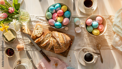 Easter breakfast table with dyed eggs, fresh bread, butter, jam, and coffee on a sunny day