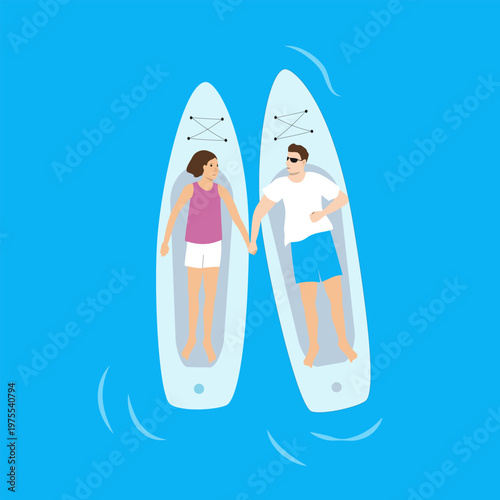 Paddle boarding. Top view on sup boards floating in clear marine water with relaxed couple on it.