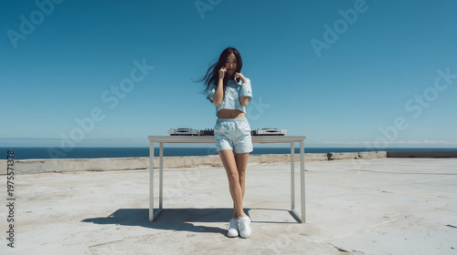 Sportliche asiatische Frau im Sommer-Outfit steht entspannt im Freien, minimalistischer Look mit viel Himmel und Copyspace, ideal für Fitness-, Lifestyle- und Fashion-Themen.