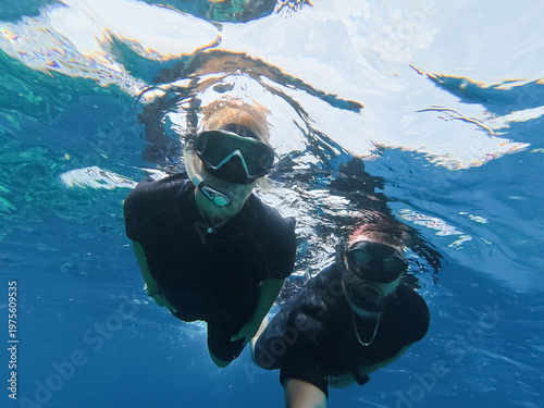 Young couple snorkeling in the crystal clear blue water of Ras Mohamed National Park, Red Sea, Sharm El Sheikh, Egypt.