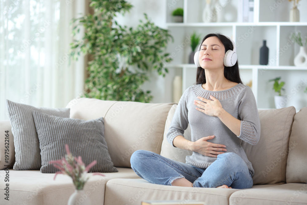 Obraz premium Asian woman wearing headphone doing breathing exercises
