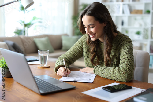 Happy tele worker filling out form working at home