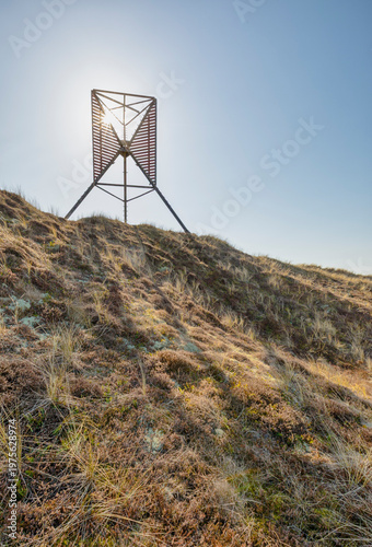 Old wooden beacon on the shore of Rinkgøbing inlet at Hvide Sande, Holmsklit spit, Denmark, in bright sunlight