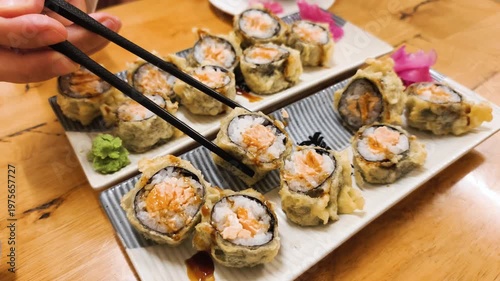 Baked Salmon rolls set features hot sushi with wasabi and ginger on restaurant table. Delicious Japanese cuisine uses Baked Salmon with spicy sauce for gourmet seafood lunch in cafe.