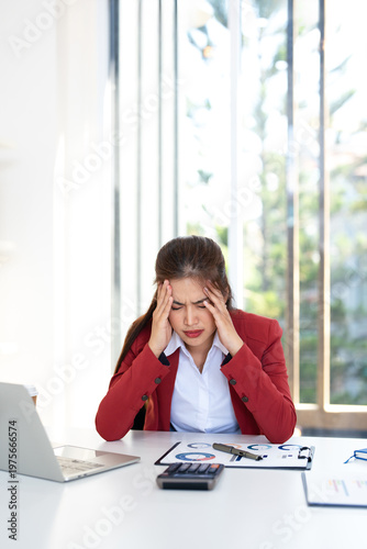 Asian businesswoman are serious at work causing headache stressed out with documents and laptop at the office.