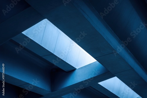 Angular Architecture With Blue Tinted Skylight Windows Showing Geometric Shadows and Contrasting Light Above A Textured Ceiling Creating A Modern Minimalist Interior Design