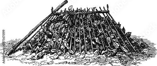 Traditional garden compost pile with wooden sticks and organic leaf debris for soil enrichment