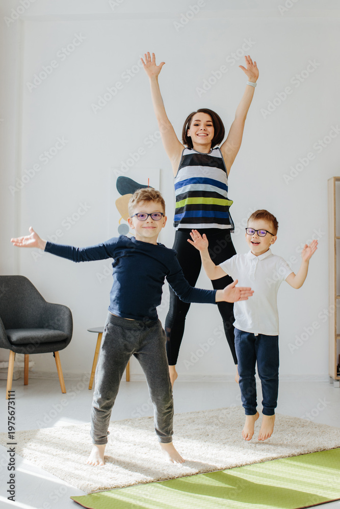 Fototapeta premium Family jumping, doing fitness exercise at home