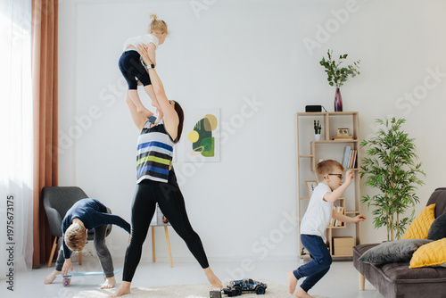 Foto Mother exercising with children at home together