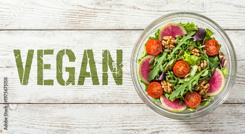 Top-down view of vibrant vegan salad bowl on rustic white wood