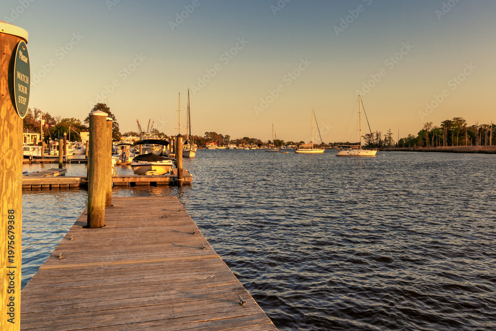 Fototapeta premium view of the historic boardwalk and waterfront of downtown Georgetown at sunset