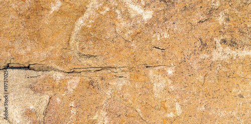 Top view of solid natural sandstone surface with rough grainy texture and horizontal crack showing detailed weathered geological pattern for construction background