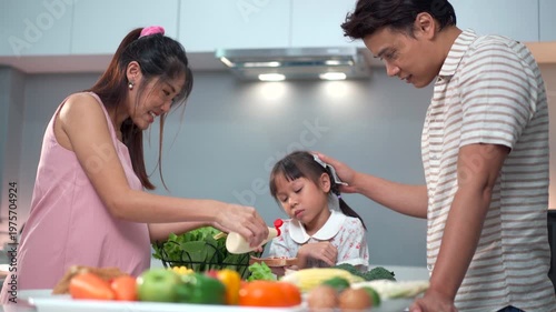 Pregnant woman and husband with little daughter cooking together