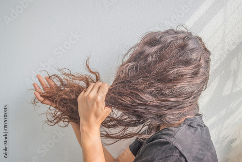 woman combing her long brown hair in the morning, white background