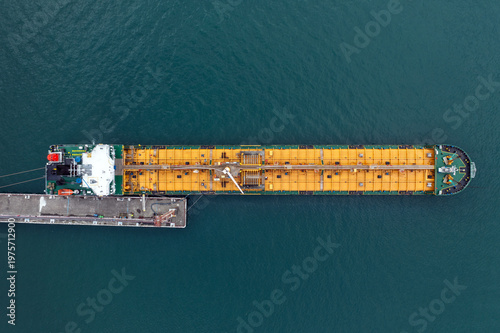 Oil tanker moored at port terminal, aerial top view from drone, petroleum transport, energy industry, maritime logistics, global trade, shipping infrastructure.