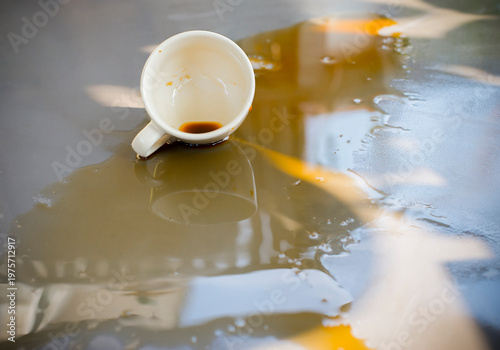 The glass spilled and coffee stained the wooden floor.