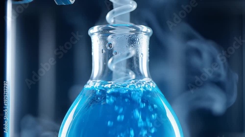 Close-up of blue liquid bubbling in a laboratory flask with steam rising science experiment