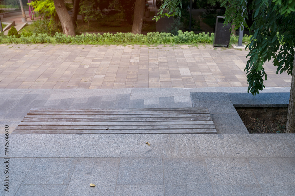 Fototapeta premium Granite stone steps leading down in a modern public park. Paved walkway perspective