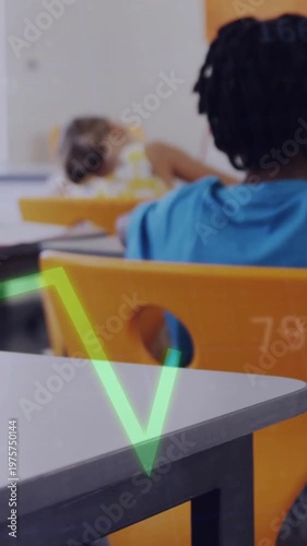 Vertical video: Student in blue tee writing camera panning driving neon graph over desk for school