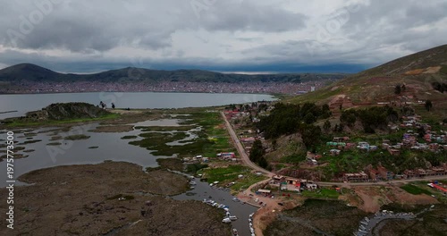 City of Puno on the shores of Lake Titicaca, the highest navigable lake in the world, in Peru. Aerial forward