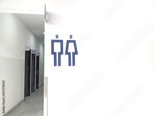 men's and women's toilets sign and restroom sign on the white wall beside the corridor and the doors of the toilet rooms, copy space for text 
