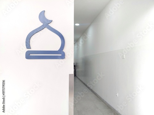 Silhouette mosque sign on the white wall beside the corridor entrance hall, copy space for text 