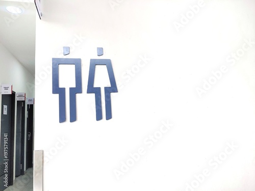 men's and women's toilets sign and restroom sign on the white wall beside the corridor and the doors of the toilet rooms, copy space for text 