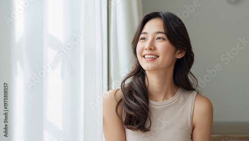 明るい窓辺で自然な笑顔を見せる若い女性の日常ライフスタイル写真 Free Download 明るい窓辺で自然な笑顔を見せる若い女性の日常ライフスタイル写真 - GFXLoad