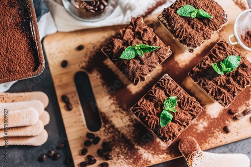 top view of homemade tiramisu cake slices with mint and ladyfingers