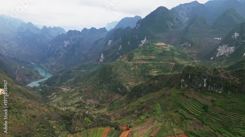 Wallpaper Mural Drone view of steep hillside agriculture with terraced fields overlooking a narrow mountain valley and a winding river flowing through isolated highland terrain in Ha Giang Province. Torontodigital.ca