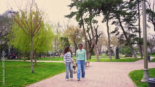 African american mother and daughter walking in a city park