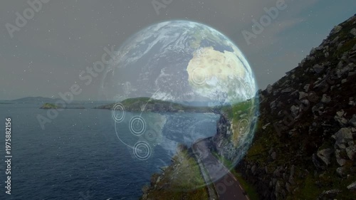 Fading in globe hologram rotating above coastal winding road at dusk, tracking HUD targets