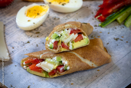 Tortilla with cucumbers, avocado, cheese, tomatoes, and hard-boiled eggs.