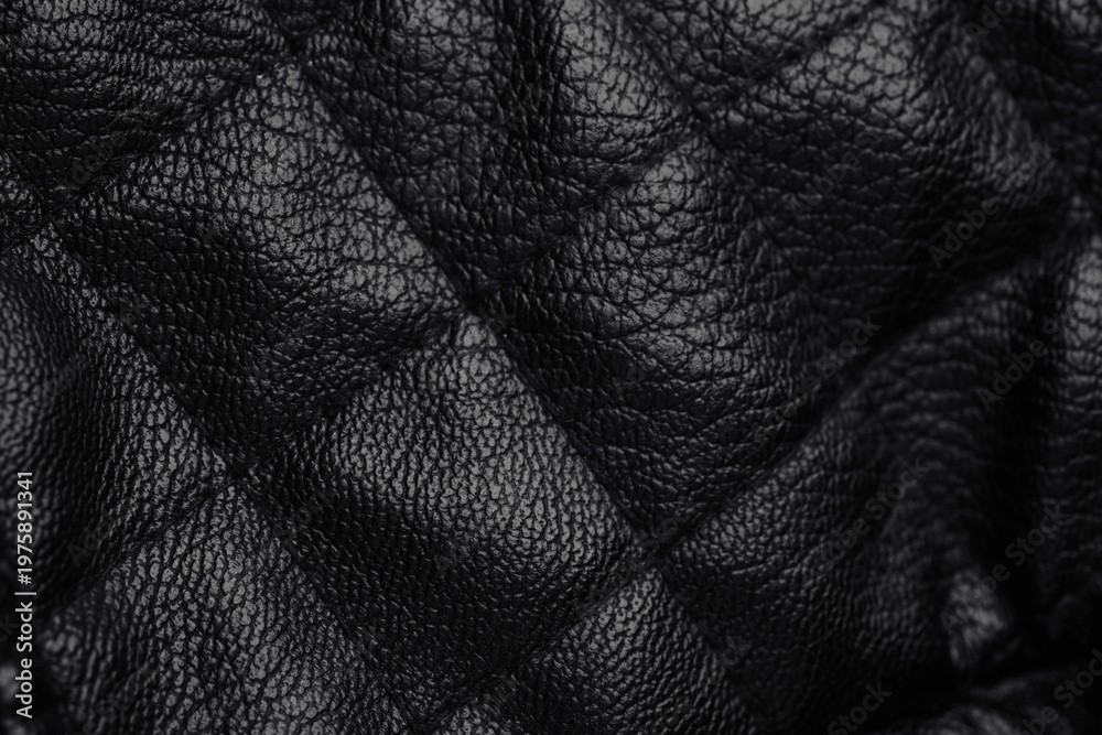Naklejka premium Detailed close up of dark black quilted leather material surface featuring classic diamond pattern