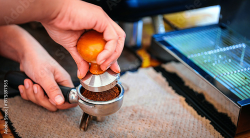 Fotografía Close-up of barista hand using tamper to press ground coffee in portafilter bask