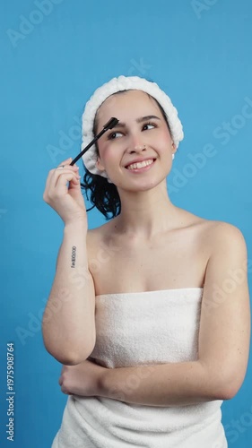 Young woman grooming eyebrows during beauty routine