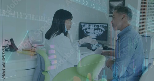 Dentist turning, picking up device, handing to patient and explaining X-ray with charts overlaying