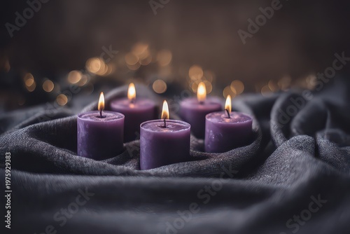 Five lit purple advent candles arranged on a textured gray fabric with bokeh lights in the background creating a warm and inviting holiday atmosphere