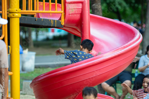 Little school boy enjoy slider outdoor playground park
