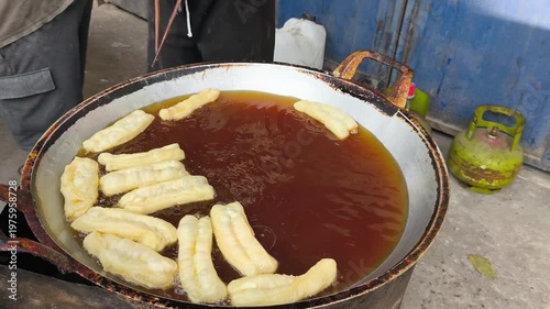 Wallpaper Mural Traditional Indonesian cakwe being deep-fried in a large pan of hot oil on a street food stall in Indonesia. Torontodigital.ca