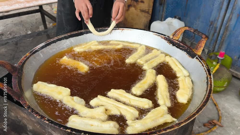 custom made wallpaper toronto digitalA person frying cakwe in a large pan of oil on a street food stall in Indonesia.