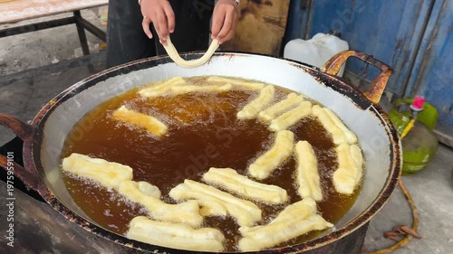 Wallpaper Mural A person frying cakwe in a large pan of oil on a street food stall in Indonesia. Torontodigital.ca
